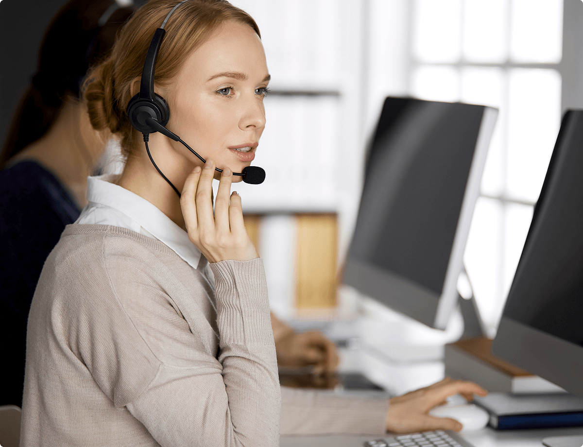 A woman wearing a headset is helping a customer over the phone, symbolizing UsenetServer’s 24/7 customer service.